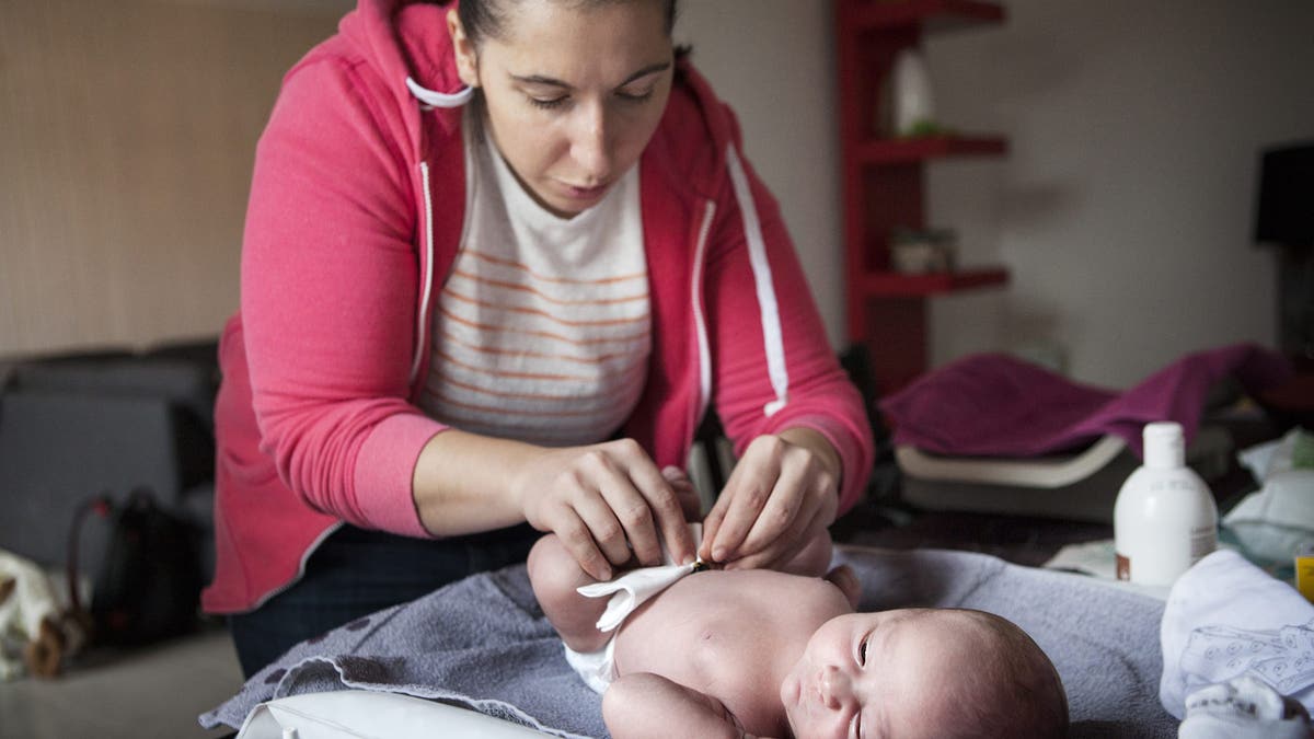 Midwife cleaning baby's umbilical cord