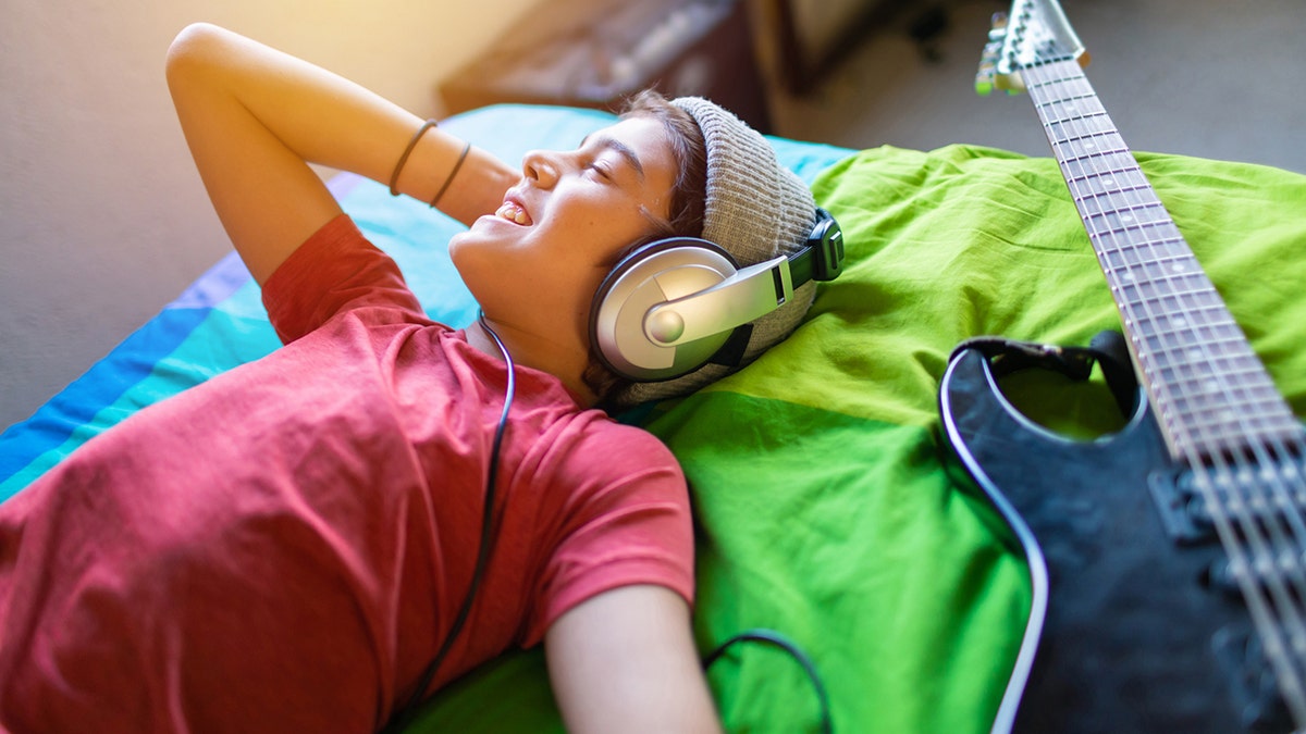 pre-teen boy listening to music in his room