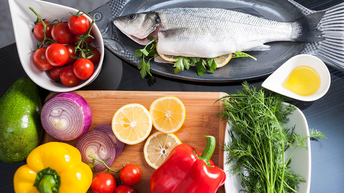 fish with lemon, vegetables, olive oil, herbs and spices