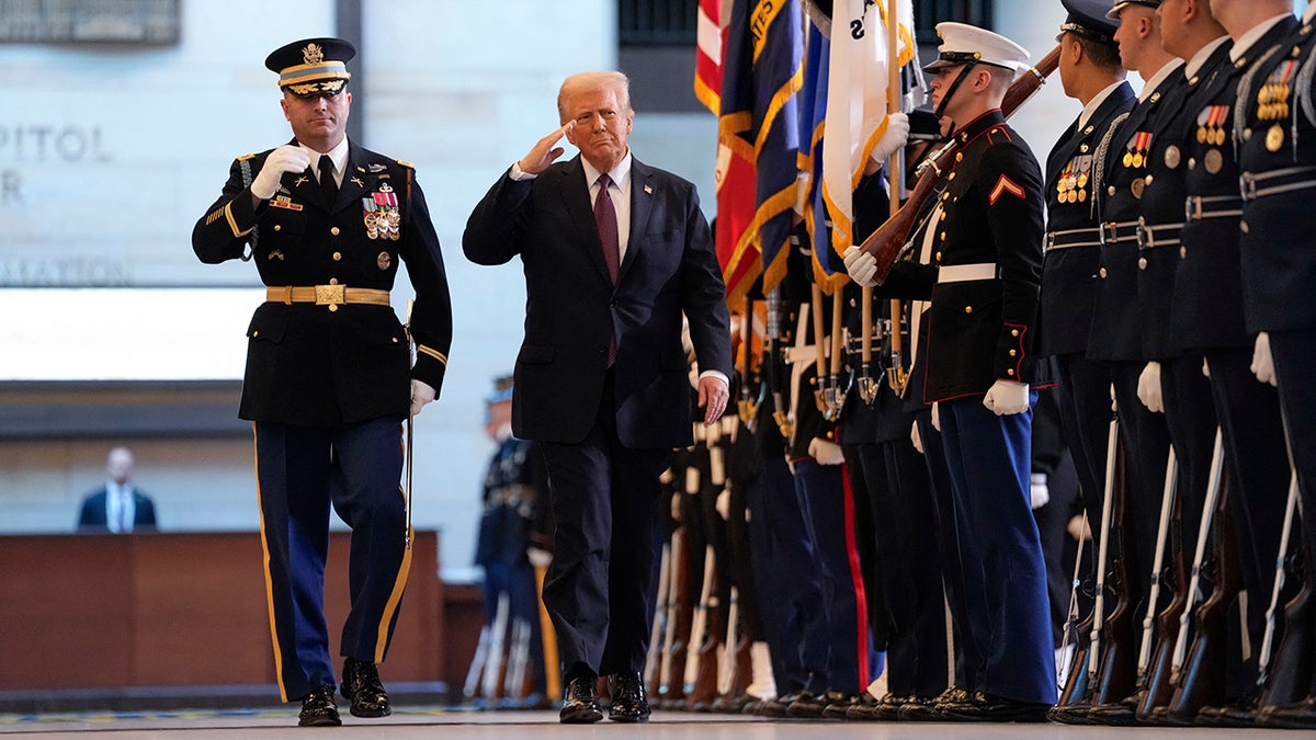 Donald Trump saluting as he reviews troops