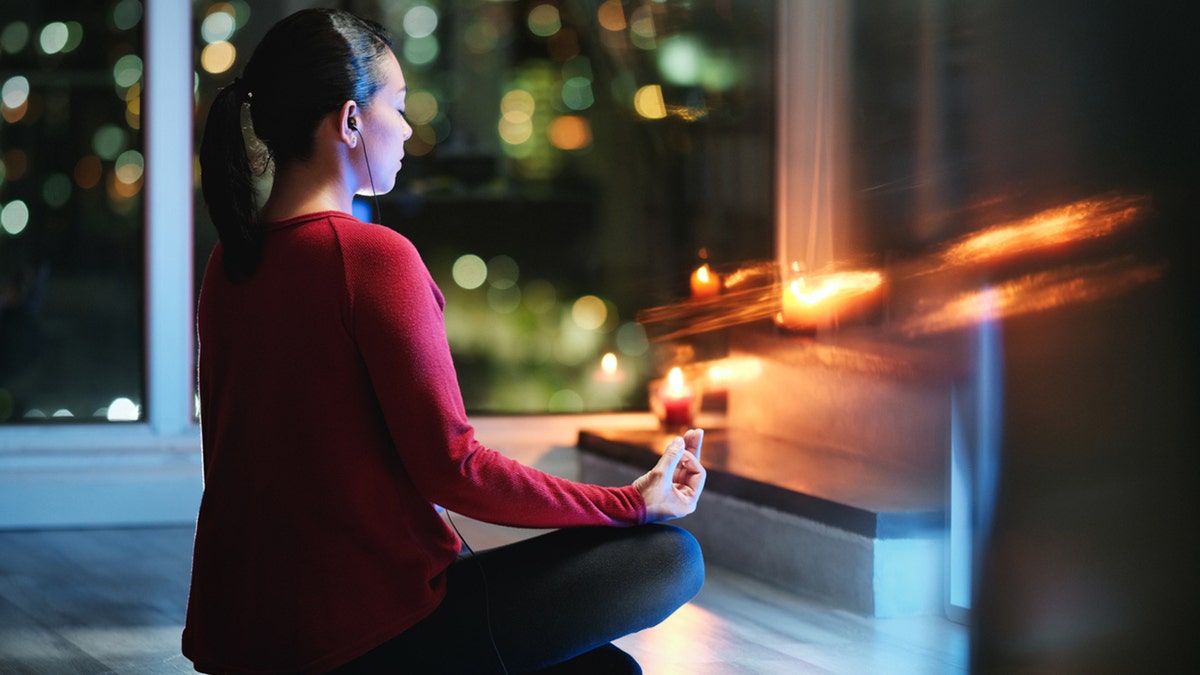 Girl doing yoga at home at night.