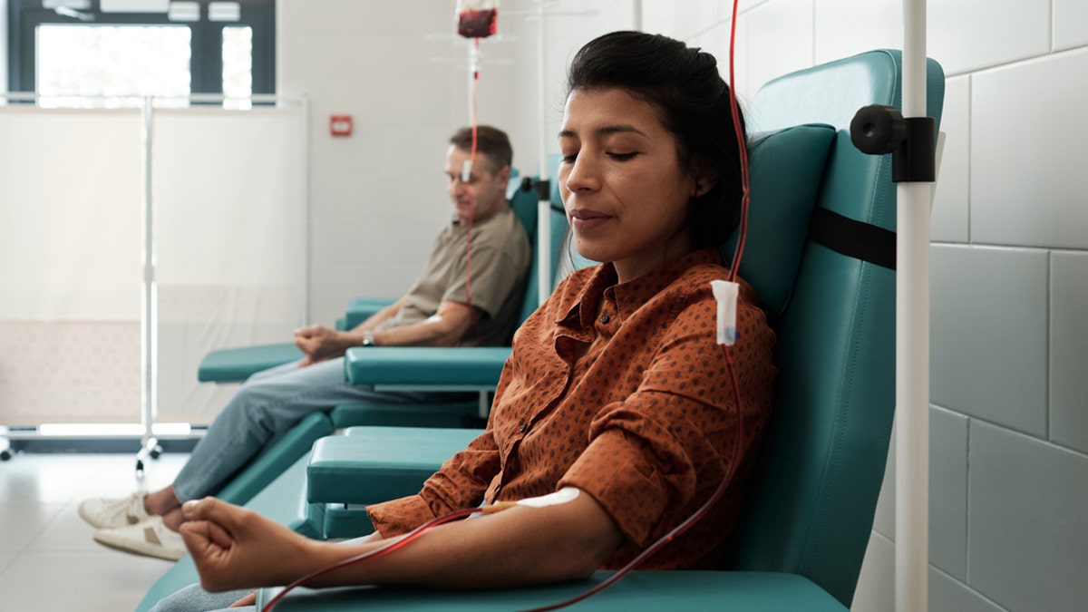 female and male donors giving blood in a hospital